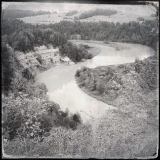 S-förmig schlängelt sich ein Fluss durch einen steilen Abhang. Schwarz-weiß-Bild-