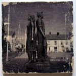Rücken an Rücken stehen ein junger Mann und eine junge Frau auf dem Hauptplatz in der schwedischen Bergbaustadt Nora