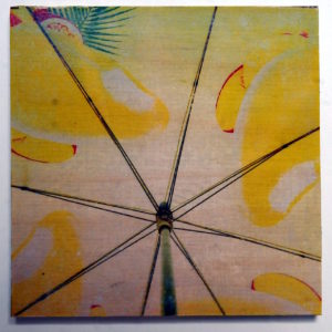 Blick von unten in einen gelben Schirm mit Früchtemotiv und Blattwerk.