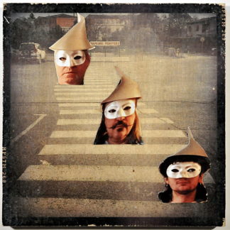 Blasses, schwarz-weißes Vintage-Bild eines Zebrastreifens. Schwarzer Rand. Drei Menschenköpfe, ausgeschnitten aus einer Postkarte collagieren die Szene. DieGesichter tragen Augenmasken und spitze Hüte.