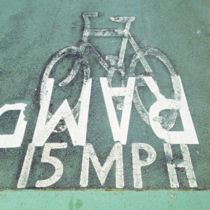 Pictogramm eines Fahrrads auf Teer mit der Schrift RAMP (über Kopf) 15MPH
