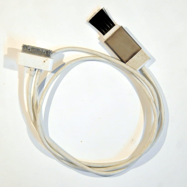 Zusammengerolltes Kabel mit breitem Anschluss für iPhone 3 und 4 und einem Rasierapparatereinigungspinsel am anderen Ende.