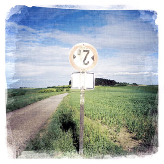 Als Durchfahrt-Verboten-Schild wurde an einem Landwirtschaftlichen Weg ein ehemaliges Maximal-2-Meter-breit-erlaubt-Schild verwendet- Die Landschaft zeigt Weite über Frühlinghaften Feldern, zerschnitten von schnurgeradem Weg.