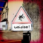 Warnschild mit stürzendem Radlerpiktogramm und der Unterschrift Geleise!
