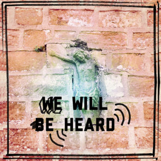 Eingemauertes Jesuskreuz in Sandsteinwand, mit Schriftzug We Will Be Heard.