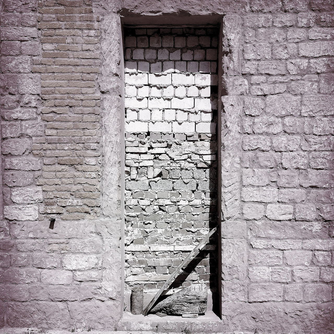 Schwarz-weiß-Bild einer zugemauerten Tür.