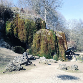 Fehlfarbenbild eines völlig mit Moos überwucherten mehrere Meter hohen geologischen Objekts, das sich auf einer freien Fläche zwischen Felsbrocken ersteckt und im Bild kaum als Wasserfall zu erkennen ist, da das Wasser zwischen Moos rinnt.