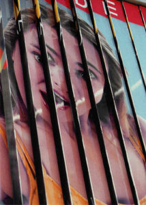 Werbeprismen einer großen französischen Werbetafels sind hängengeblieben und zeigen das Gesicht einer jungen Frau, aufgeteilt in etwa acht Lamellen.