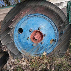 Destruktives, in Striche von 45 Grad zerlegtes Bild eines Wagenrads mit Gummibereifung und blauer Felge, deren Kern bei der nabe rosaort strahlt.