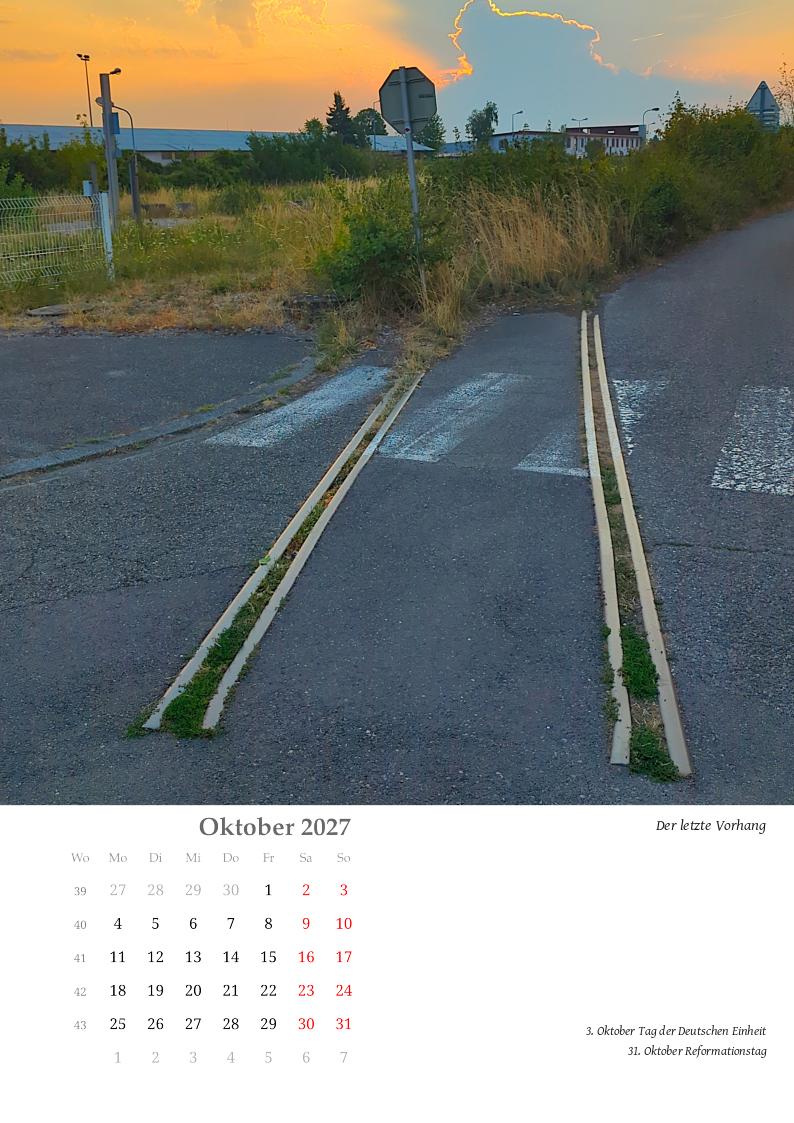 Abrupt endet eine Schiene im Teer, nachdem sie einen Zebrastreifen durchquerte. Im Hintergrund geht hinter hohen Gewitterwolken die Sonne auf und akzentuiert deren Umriss.